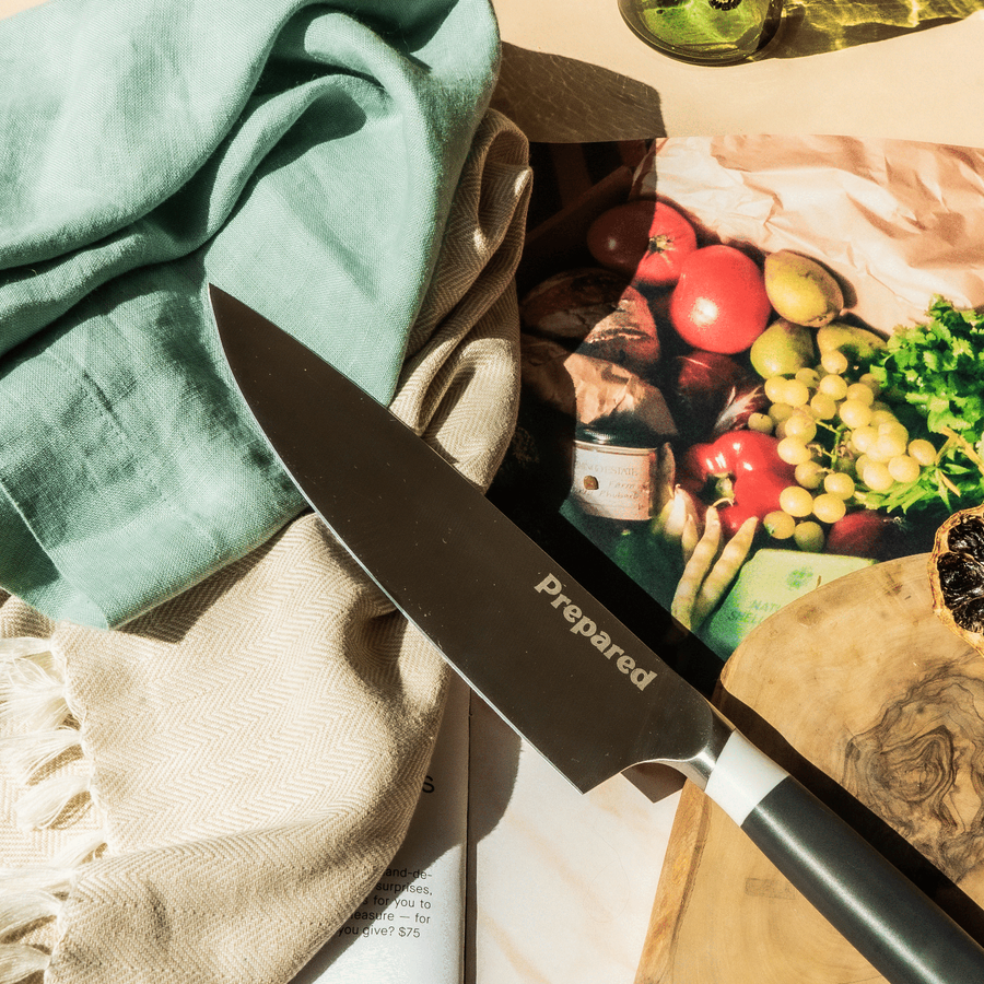 The Chef's knife on a kitchen napkin and wooden board