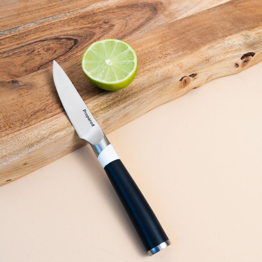  paring knife resting on a cutting board and half a lime